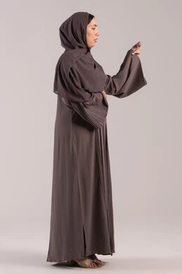 اتباع تعليمات السلامة الوقائية، الإحساس بالمرض والإرهاق، الحاجة لزيارة الطبيب ووضع خطة علاجية، الإصابة بالحمى والتعب، بورتريه  من الجانب لامرأة عربية خليجية اماراتية محجبة ترتدي عباءة تحمل بيدها ميزان حرارة رقمي، شابة سعودية مريضة،  الجسم بالطول الكامل, خلفية بنية