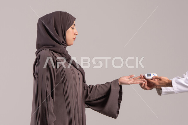 Controlling blood sugar through home measuring devices, a close-up portrait of a nurse's hand wearing a uniform checking the blood sugar level of an Arab Gulf Emirati patient wearing an abaya, home healthcare companies, quick medical check-up at home, brown background.