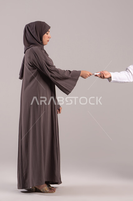 Monitoring blood sugar levels using home tools, a close-up portrait of a nurse's hand wearing a uniform checking the blood sugar level of an Arab Gulf Emirati patient wearing an abaya, home healthcare companies, quick medical check-up at home, brown background.