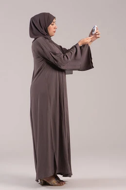 أضرار ارتفاع نسبة الجلوكوز, جهاز إلكتروني حديث لمرضى داء السكري, حالات مرضية ومشاكل وآلام جسدية, الرعاية الصحية والفحص الطبي السريع, بورتريه من الجانب لامرأة عربية خليجية إماراتية تقوم بفحص نسبة السكر في الدم, شابة سعودية مريضة، الجسم بالطول الكام, خلفية بنية