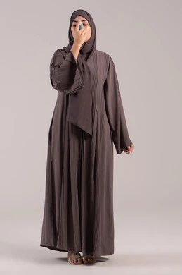 المحافظة على ممرات الهواء, شابة سعودية مريضة، مشاكل في الجهاز التنفسي، بورتريه لامرأة عربية خليجية اماراتية محجبة ترتدي عباءة تحمل بيدها جهاز الرذاذ الخاص بمرض الربو تقوم باستنشاق أدوية الكحة، صورة الجسم بالطول الكامل، خلفية بنية