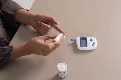 New medical technology for diabetes patients, medical conditions and problems and physical pains, vertical overhead portrait of an Emirati Gulf Arab woman checking her blood sugar level, healthcare and rapid medical examination, problems of high blood sugar, a sick young Saudi woman, brown background.