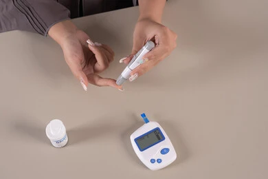 A sick young Saudi woman, a modern electronic device for diabetes patients, medical conditions and problems and physical pains, a vertical overhead portrait of an Emirati Gulf Arab woman checking her blood sugar level, healthcare and rapid medical examination, problems of high blood sugar, brown background.