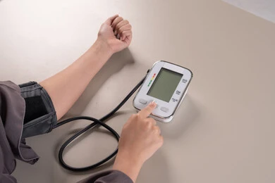 استخدام الميزان الاكتروني الحديث والمتطور للفحص المنزلي السريع , العناية والاهتمام والحفاظ على الصحة, المتابعة الدورية لفحص الدم, بورتريه مقرب ليد امراة عربية خليجية  اماراتية ترتدي العباءه تقوم بقياس ضغط الدم , مفهوم الطب والرعاية الصحية, خلفية بنية