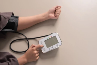 العناية والاهتمام والحفاظ على الصحة, المتابعة الدورية لفحص الدم, بورتريه مقرب ليد امراة عربية خليجية  اماراتية ترتدي العباءه تقوم بقياس ضغط الدم باستخدام الميزان الالكتروني, مفهوم الطب والرعاية الصحية, خلفية بنية