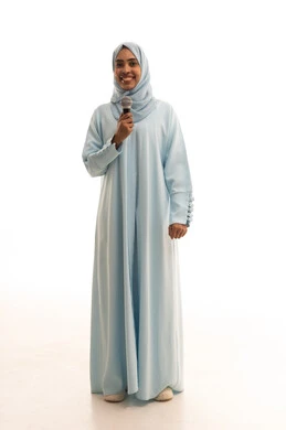 التدريب الصوتي وتقديم البرامج الاذاعيه، فن إلقاء الخطابات والندوات، بورتريه لشابة عربية خليجية سعودية ترتدي العباءة و الحجاب تمسك بيدها الميكروفون، ايماءات وتعابير وجه و يدين تعبر عن الغناء والطرب،الجسم بالطول الكامل، خلفية بيضاء