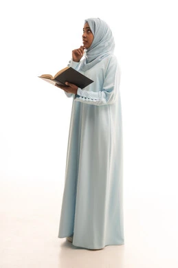 Spending time reading, learning, and culture, expressions of thinking about something, gestures of contemplation and focus, the concept of self-learning, a portrait of an Arab Gulf Saudi woman wearing an abaya and hijab reading a book, full-body, white background.