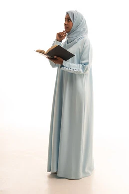 تعابير التفكير فى شيء ما، قضاء الوقت بالقراءة والتعلم والثقافة، ايماءات التمعن والتركيز، مفهوم التعلم الذاتي، بورتريه لامراة عربيه خليجيه سعودية ترتدي العباءة و الحجاب تقوم بمطالعة كتاب، الجسم بالطول الكامل، خلفية بيضاء