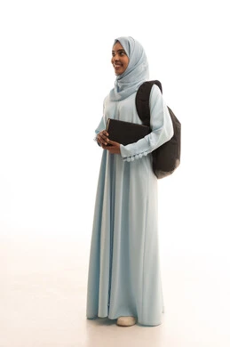 التجهيز للعام الدراسي الجامعي، التعليم العالي في جامعات المملكة، المناهج والمواد التعليمية الحديثة، بورتريه لطالبة جامعية عربية خليجية سعودية محجبة ترتدي حقيبة الظهر تحمل كتاب بايماءات السرور، صورة لكامل الجسم، خلفية بيضاء