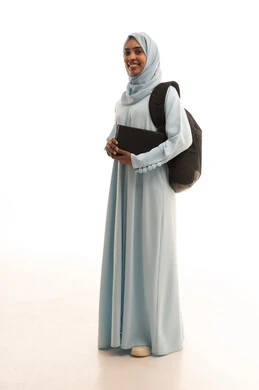 Preparation for the new academic year, higher education in the universities of the Kingdom, modern curricula and educational materials, a portrait of a veiled Arab Gulf Saudi university student wearing a backpack and holding a book with gestures of joy, full-body image, white background.