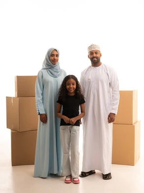 ايماءات وجه تدل على السعادة والانسجام، نقل العفش لبيت جديد من خلال العديد من الصناديق متعددة الأحجام ، بورترية  لعائلة عربية خليجية عمانية سعيدة داخل المنزل الجديد ، امتلاك بيت جديد، خلفية بيضاء