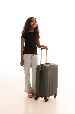 الاستعداد للسفر والرحلات السياحيه، قضاء أوقات ممتعه في العطلة الصيفيه، بنت عربيه خليجيه سعودية مبتسمة ترتدي الزي الكاجوال تمسك بحقيبة السفر تنظر الى شيء ما، الجسم بالطول الكامل، خلفية بيضاء