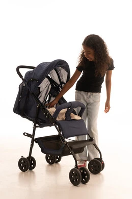 تقوية رابطة الأخوة، بورتريه لبنت عربية خليجية سعودية ترتدي الزي الكاجوال تقف بجانب عربة الأطفال بإيماءات تدل على السعادة و المحبة، مفهوم الأسرة السعيدة ، قضاء أوقات عائلية ممتعة، الجسم بالطول الكامل، خلفية بيضاء