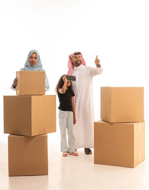 مفهموم امتلاك سكن جديد والاستقرار العائلي، بنت ترتدي نظارة الواقع الإفتراضي ثلاثية الأبعاد ، بورتريه لعائلة عربية خليجية سعودية تقوم بالنقل الى منزل جديد،الاشارة الى شيء ما،  صورة الجسم بالطول الكامل، خلفية بيضاء