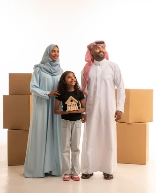 Cardboard boxes and containers, a girl holding a model of a small house, a portrait of a Saudi Arabian Gulf family wearing traditional attire looking up at something, moving furniture to a new house, owning a new residence, family teamwork, full-body, white background.