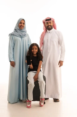 A black screen displayed on a mobile phone, the use of technologies and tourism applications and hotel bookings, the concept of tourism and travel, a portrait of a Saudi Gulf Arab girl wearing casual attire holding a mobile phone sitting on a suitcase with her parents, white background.