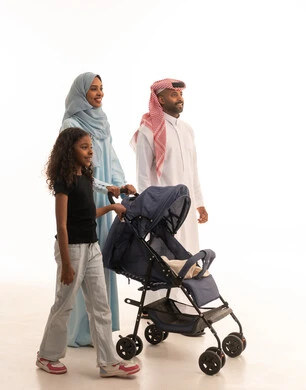 أهمية الأهل ودورهم الأساسي في تربية ونشأة الأبناء، عائلة سعودية تقضي اوقات ممتعة، الرعايه والاهتمام بالأولاد, بورتريه لرجل عربي خليجي سعودي يرتدي الثوب التقليدي و الشماغ  يقف مع زوجته وابنته ويقوم بجرعربة الأطفال، القيام بالنزهات والجولات العائلية، خلفية بيضاء