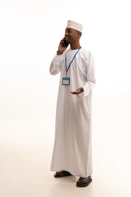 اجراء مكالمة هاتفية عبر الجوال ، موك أب أبيض مستطيل , بورتريه لشاب عربي خليجي عماني اسمر يرتدي الدشداشة والكمة ينظر بايماءات السعادة , ارتداء بادج شخصي, بطاقة تعريفية شخصية باسم الموظف, خلفية بيضاء