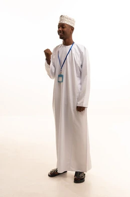 Wearing a personal badge, a personal identification card with the employee's name, a white rectangular mock-up, looking at the camera with expressions of joy, a portrait of a young Arab Gulf Omani man with a dark complexion wearing a dishdasha and a kumma, looking with gestures of happiness, white background.