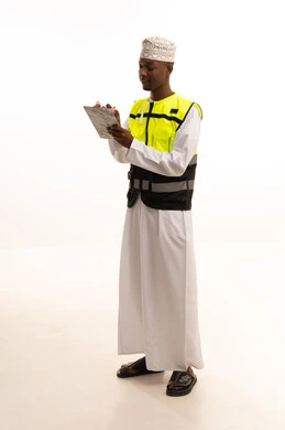 الإعمار بسواعد أبناء الوطن، تدوين وكتابة الملاحظات الهامة ،مفهوم الهندسة والانشاءات المعمارية، بورتريه لمهندس عربي خليجي سعودي اسمر يرتدي الثوب التقليدي والسترة الخاصة وخوذة الحماية يقف وبيده دفتر الملاحظات، الجسم بالطول الكامل، خلفية بيضاء