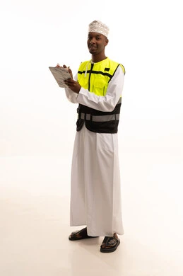 تدوين وكتابة الملاحظات الهامة ،مفهوم الهندسة والانشاءات المعمارية، الإعمار بسواعد أبناء الوطن، بورتريه لمهندس عربي خليجي سعودي اسمر يرتدي الثوب التقليدي والسترة الخاصة وخوذة الحماية يقف وبيده دفتر الملاحظات، الجسم بالطول الكامل، خلفية بيضاء