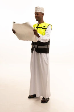 Gestures of joy and happiness, the concept of engineering and architectural constructions, professionalism in planning, direct monitoring and supervision of work, a portrait of an Arab Gulf Omani engineer with a dark complexion wearing a dishdasha, kumma, and special jacket, and a safety helmet standing with an engineering plan in hand, full-body, white background.