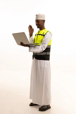 Conducting a live broadcast via laptop, using modern technology and techniques in work, the concept of engineering and architectural constructions, a portrait of a dark-skinned Arab Gulf Omani engineer wearing a dishdasha, kumma, and special jacket, and a safety helmet standing with a laptop in hand, full-body, white background. Conducting a live broadcast via laptop, using modern technology and techniques in work, the concept of engineering and architectural constructions, a portrait of a dark-skinned Arab Gulf Omani engineer wearing a dishdasha, kumma, and special jacket, and a safety helmet standing with a laptop in hand, full-body, white background.