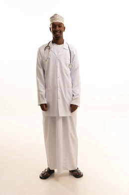 العمل في المستشفيات والمراكز الطبية،تقديم الخدمات العلاجية للمرضى برحابة صدر، مفهوم الطب والرعاية الصحية، بورتريه لطبيب عربي خليجي عماني اسمر يرتدي الدشداشة والكمة  والمعطف الأبيض ينظر بتعابير السعادة، خلفية بيضاء