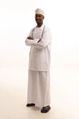 مفهوم الطب والرعاية الصحية، تقديم الخدمات العلاجية للمرضى برحابة صدر، بورتريه لطبيب عربي خليجي عماني اسمر يرتدي الدشداشة والكمة  والمعطف الأبيض ينظر بتعابير السعادة، العمل في المستشفيات والمراكز الطبية، خلفية بيضاء