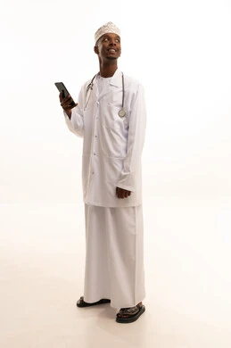 استخدام التكنولوجيا في البحث والتطوير،اجراء مكالمة هاتفية ،  تقديم الخدمات للمرضى بكل كفاءه، اجراء الاستشارات الطبيه عن بعد، بورتريه لشاب عربي خليجي عماني اسمر يرتدي الدشداشة والكمة مع المعطف الابيض يستخدم الهاتف المحمول، مهن ووظائف صحية، خلفيه بيضاء