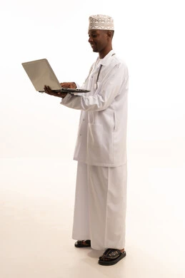 استخدام التكنولوجيا في البحث والتطوير، تقديم الخدمات للمرضى بكل كفاءه، اجراء الاستشارات الطبيه عن بعد، بورتريه لشاب عربي خليجي عماني اسمر يرتدي الدشداشة والكمة مع المعطف الابيض يعمل على جهاز الحاسوب المحمول، مهن ووظائف صحية، خلفيه بيضاء
