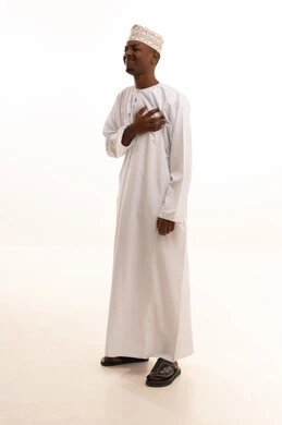 الشعور في زيادة معدل ضربات القلب, التعب والإرهاق والضغوطات النفسية, الاحساس بذبحه صدريه،بورتريه لشاب عربي خليجي عماني اسمر  يرتدي الدشداشة والكمة يضع يده على قلبه ويشعر بحالة سيئة من الوخز والألم, اضطرابات وأمراض قلبية, خلفية بيضاء