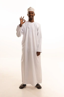 علامة الجودة والامتياز،بورتريه لشاب عربي خليجي عماني اسمر يرتدي الدشداشة والكمة  يشير بيده بإيماءات وتعابير وجه و يدين تدل على الاعجاب، التعبير عن الجودة والاتقان، القبول والموافقة والرضا، خلفية بيضاء