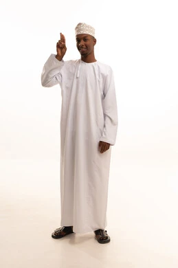 ايماءات السرور والسعادة, مفهوم السلام والترحيب, تعابير الوجه ولغة الجسد المختلفة, بورتريه لشاب عربي خليجي عماني اسمر يرتدي الدشداشة والكمة يرفع اليد اليمني لإلقاء التحية,  صورة الجسم بالطول الكامل، خلفية بيضاء