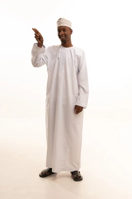 The concept of peace and welcome, different facial expressions and body language, a portrait of a young Arab Gulf Saudi man with a dark complexion wearing a white thobe raising his right hand to greet, gestures of joy and happiness, full-body image, white background.