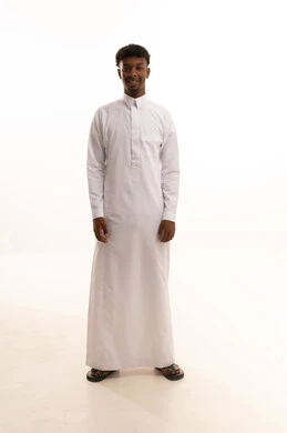 بورتريه لشاب عربي خليجي سعودي اسمر يرتدي الثوب الابيض ينظر بتعابير السرور،مفهوم الرجولة والثقة بالنفس، الاهتمام بالمظهر الخارجي والأناقة،  الوقوف باستقامة وثبات، صورة الجسم بالطول الكامل، خلفية بيضاء