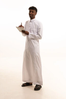 Organization and management of business, noting and recording observations and information on paper, a portrait of a young Arab Gulf Saudi man with a tan wearing a white thobe writing daily tasks and goals, white background.