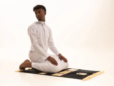 آداء صلاة التراويح ،الركوع والسجود والخشوع لله، بورتريه لشاب عربي سعودي خليجي اسمر يرتدي الثوب التقليدي يقف على السجادة و يؤدي فريضة الصلاة ، الدعاء والتضرع الى الله، أذكار وأدعية وفرائض، خلفية بيضاء.