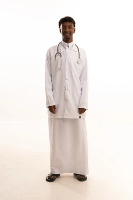 The concept of medicine and healthcare, working in the Saudi health sector, conducting necessary examinations, a portrait of a smiling Saudi Gulf doctor with a dark complexion wearing traditional attire and a white coat, looking with expressions of joy as he provides his services to patients with great efficiency, white background.