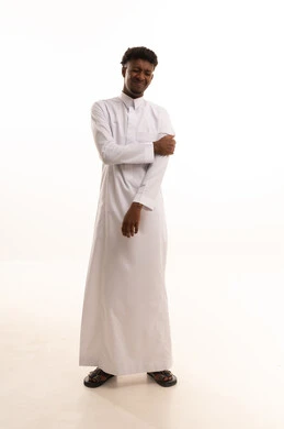 الأوجاع والآلام العصبية والعضلية، طلب المساعده والحاجه للعلاج، التهاب العضلات والمفاصل، بورتريه لشاب عربي خليجي سعودي اسمر يرتدي الثوب الأبيض يضع يده على كتفه بايماءات الألم والتعب والأرهاق، حالة اسعافية طارئة، صورة الجسم الطول الكامل, خلفية بيضاء