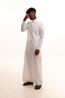 الإحباط والحزن على ضياع الفرصة، بورتريه لشاب عربي خليجي سعودي اسمر يرتدي الثوب الابيض  يضع يده على رأسه بتعابير الحسرة والندم، الأسف عل خسارة شيء ما ذو قيمة، خيبة الأمل والتعرض لخذلان وصدمة،خلفية بيضاء