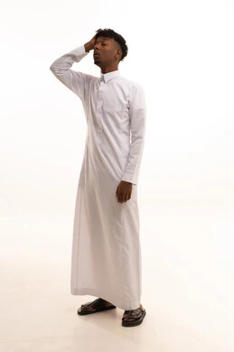 خيبة الأمل والتعرض لخذلان وصدمة، الأسف عل خسارة شيء ما ذو قيمة، الإحباط والحزن على ضياع الفرصة، بورتريه لشاب عربي خليجي سعودي اسمر يرتدي الثوب الابيض  يضع يده على رأسه بتعابير الحسرة والندم، خلفية بيضاء