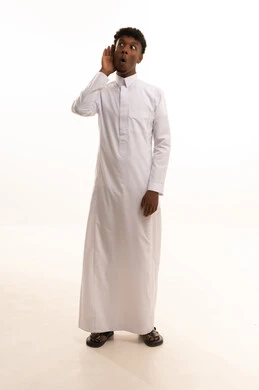 الانصات وحسن الاستماع، بورتريه لشاب عربي خليجي سعودي اسمر يرتدي الثوب الابيض يضع يده خلف أذنه بإيماءات التنصت والتجسس، التركيز على الكلام وسماع الاسرار، خلفية بيضاء