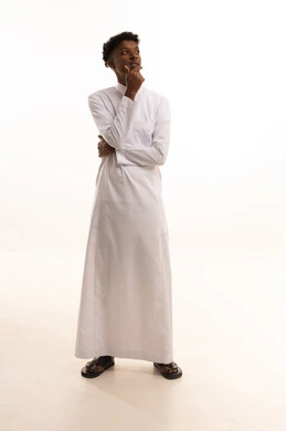 Aspirations and planning for the future, problem-solving and decision-making, a portrait of a young Arab Gulf Saudi man with a dark complexion wearing a white thobe, resting his hand on his chin with gestures of thinking and distraction, the concept of listening and focus, white background.