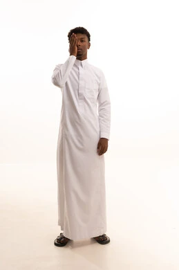 Eye strength test and examination, the concept of vision assessment, a portrait of a young Arab Gulf Saudi man with a dark complexion wearing a white thobe, placing his hand over his eye, gestures for eye examination, white background.