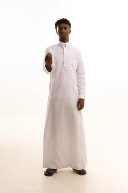 مفهوم الصبر والتريث و التأني, التهديد و التوعد لشيء ما، بورتريه لشاب عربي خليجي سعودي اسمر يرتدي الثوب الأبيض  ينظر الى الكاميرا يرفع يده نحو الأعلى بإيماءات طلب الإنتظار, خلفية بيضاء