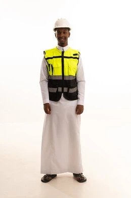 بورتريه لمهندس عربي خليجي سعودي اسمر مبتسم يرتدي الثوب التقليدي والخوذه وسترة الحماية ينظر بإيماءات السرور، مهن ووظائف سعودية، الإعمار بسواعد أبناء الوطن ، مفهوم الهندسة والانشاءات المعمارية، العمل في القطاع الهندسي،خلفية بيضاء