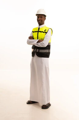 مفهوم الهندسة والانشاءات المعمارية، العمل في القطاع الهندسي،بورتريه لمهندس عربي خليجي سعودي اسمر مبتسم يرتدي الثوب التقليدي والخوذه وسترة الحماية ينظر بإيماءات السرور، مهن ووظائف سعودية، الإعمار بسواعد أبناء الوطن ، خلفية بيضاء