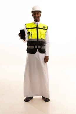 Black screen display, using modern technology and techniques in work, monitoring and supervising work via mobile, construction by the hands of the nation's sons, the concept of engineering and architectural constructions, a portrait of a Saudi Arabian Gulf Arab engineer with a dark complexion wearing traditional dress and a special jacket and a safety helmet standing with a mobile phone in hand, full body, white background.