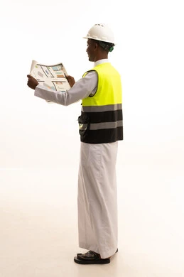 مفهوم الهندسة والانشاءات المعمارية، الاحتراف فى التخطيط، المتابعة والإشراف على العمل بشكل مباشر، الإعمار بسواعد أبناء الوطن، بورتريه لمهندس عربي خليجي سعودي اسمر يرتدي الثوب التقليدي والسترة الخاصة وخوذة الحماية يقف وبيده مخطط هندسي ، الجسم بالطول الكامل، خلفية بيضاء